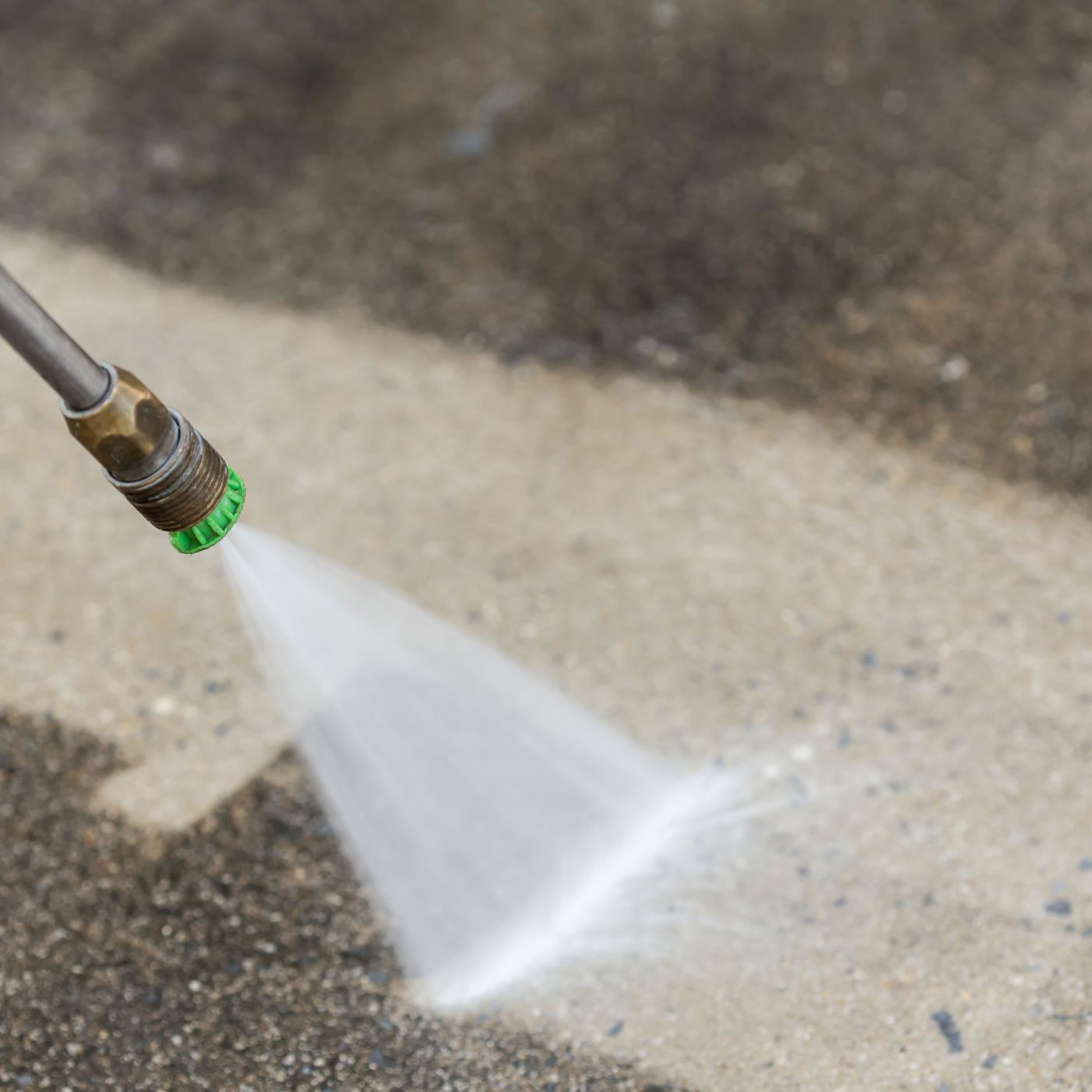 cleaning a sidewalk with a pressure washer